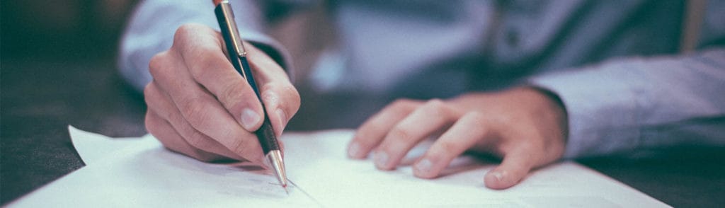 Man writing on paper with a pen